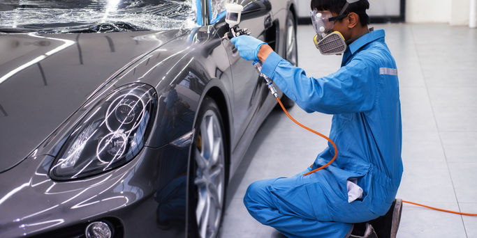 Professional technician Spraying the varnish to the car Ready to wear protective gear
