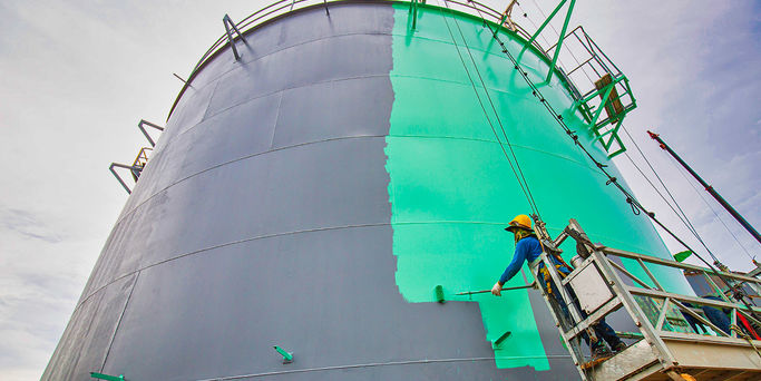 Male-worker-takes-the-aerial-cableway-with-an-industrial-paint-brush